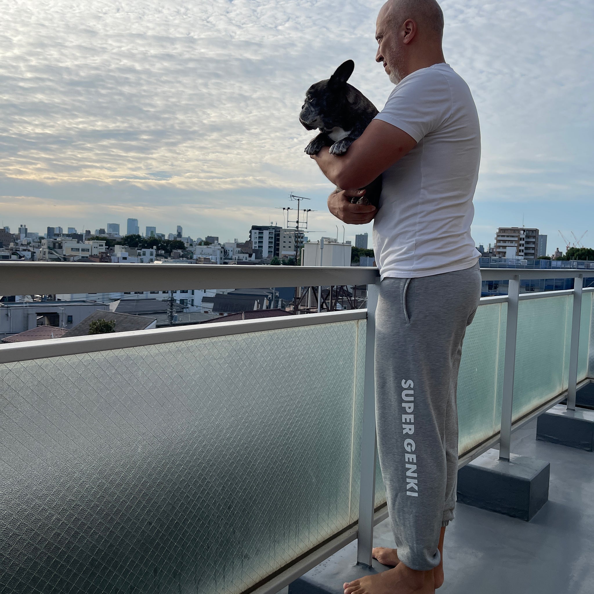 Porco and Tony wearing Super Genki gray sweatpants on our Tokyo balcony overlooking the Shinjuku skyline.