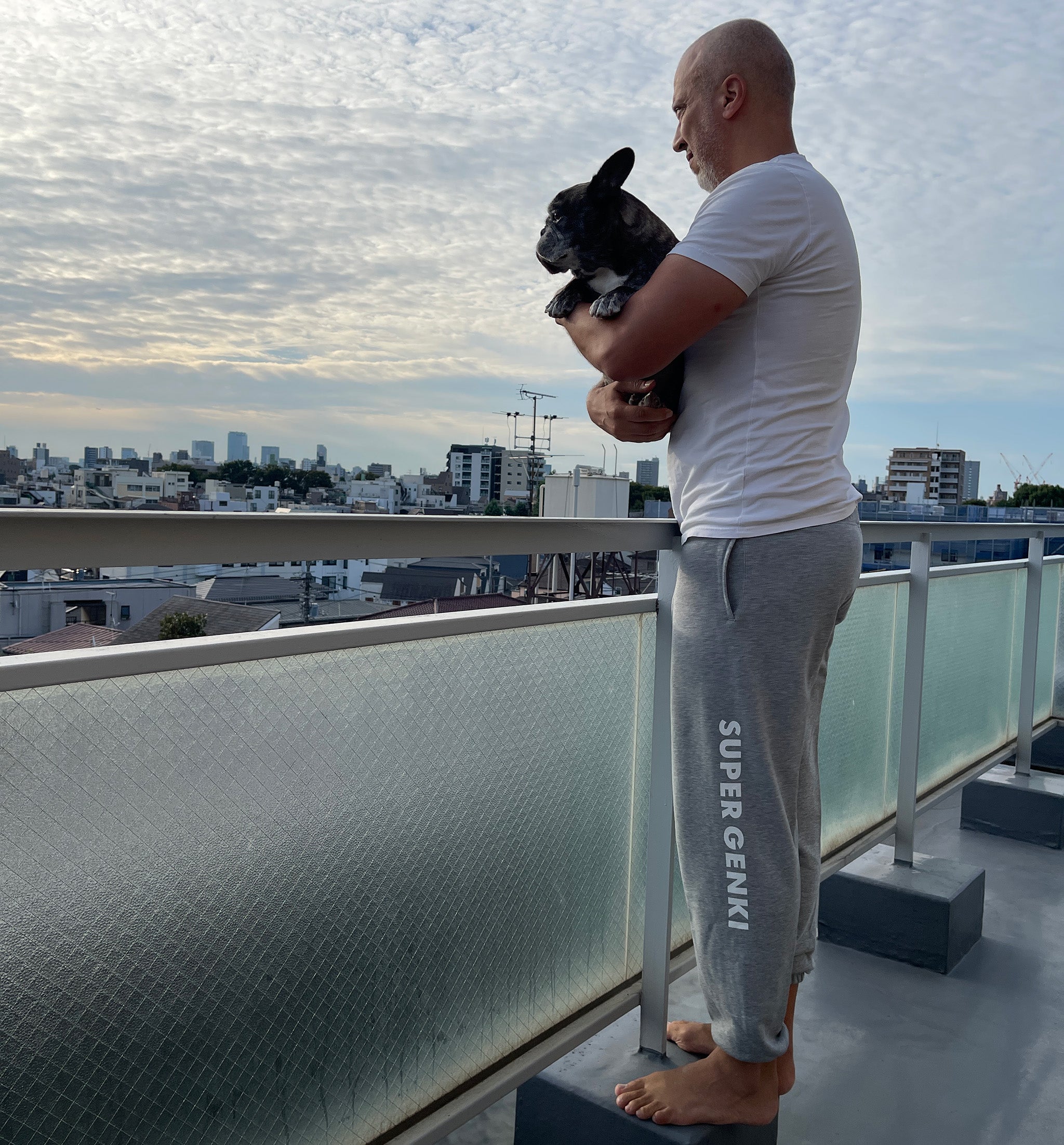 Porco and Tony wearing Super Genki gray sweatpants on our Tokyo balcony overlooking the Shinjuku skyline.