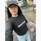 Super Genki customer wearing a black 'SUPER GENKI' long-sleeve t-shirt on a Tokyo street.